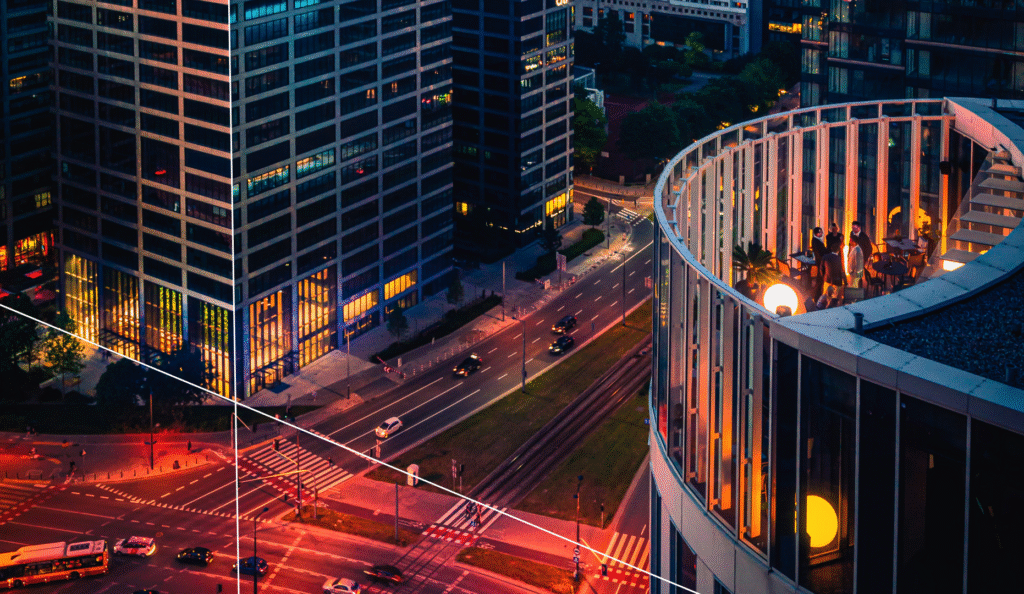 Smart city at dusk with modern office towers, busy intersection, and rooftop gathering — symbolizing interconnected infrastructure, human-centric design, and ongoing urban maintenance challenges