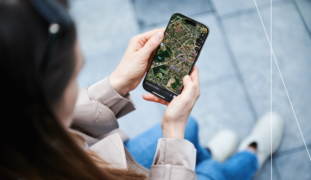 Woman using smartphone with digital city map to explore urban data in real time, symbolizing citizen engagement and smart city solutions.
